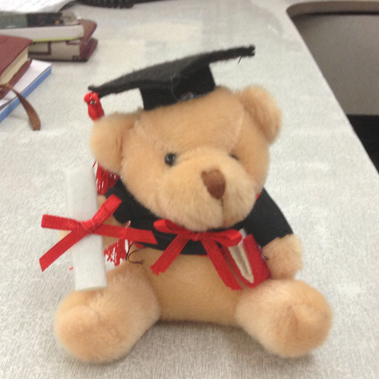 Plush bear surrounded by graduation items