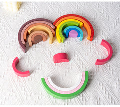 Toddler playing with rainbow stacker toy