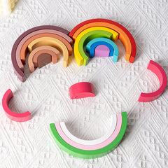 Person demonstrating a stacking challenge with rainbow toy