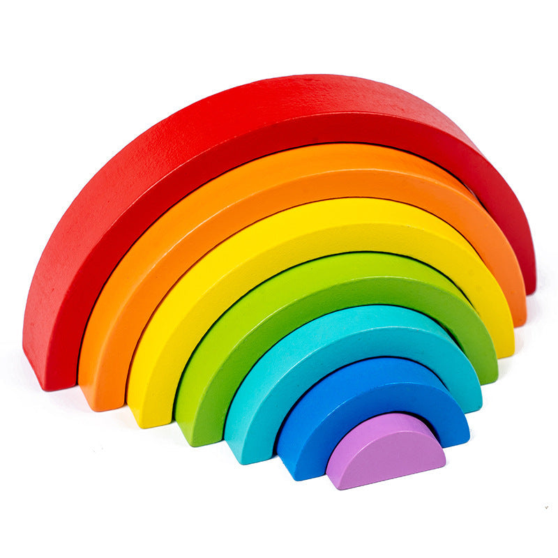 Toddler playing with rainbow stacker toy