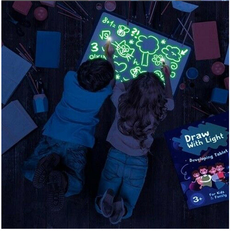 Child drawing on the glow pad in a dark environment