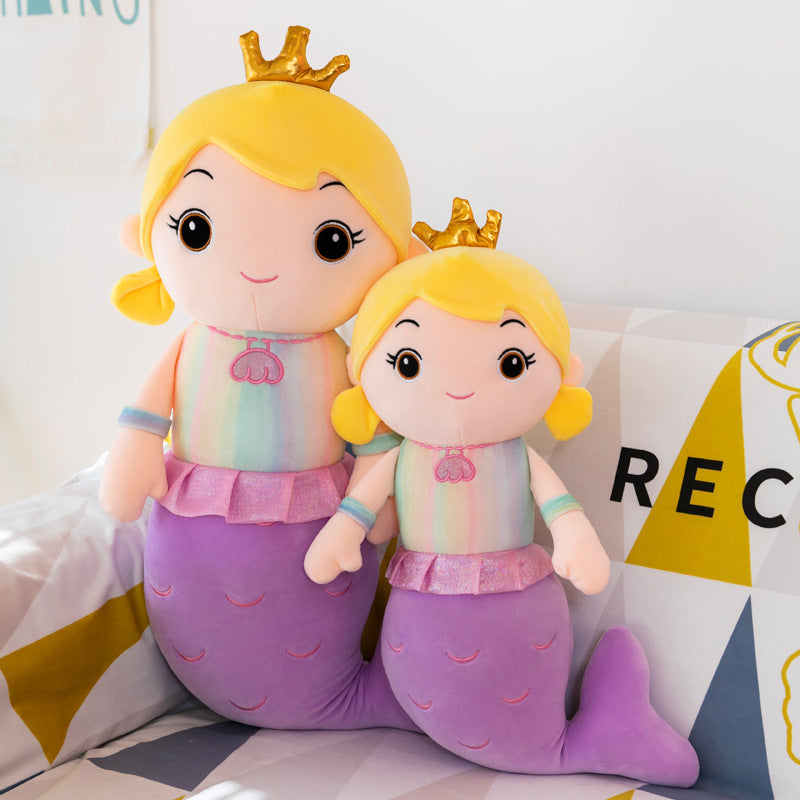 Child hugging the plush mermaid doll