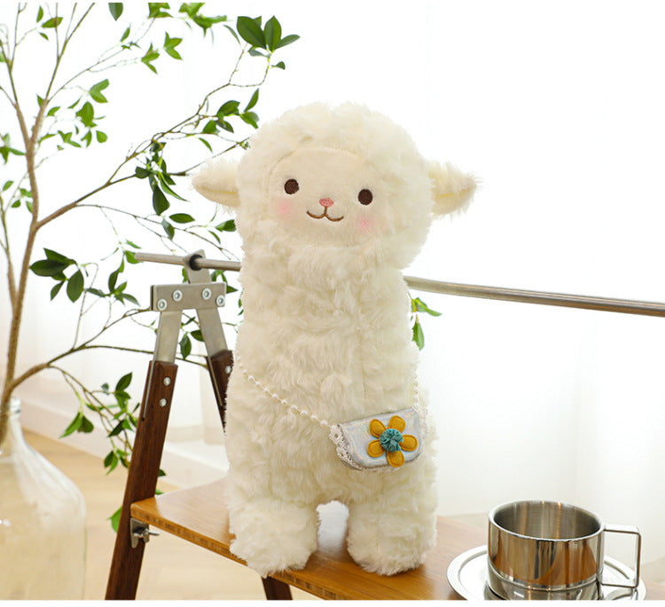 alpaca plush toy laid on grass