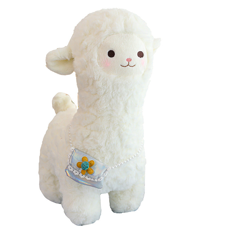 alpaca plush toy laid on grass