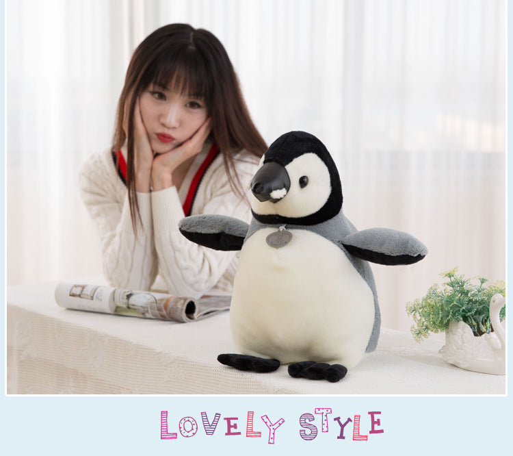 Penguin Doll on a bed with toys
