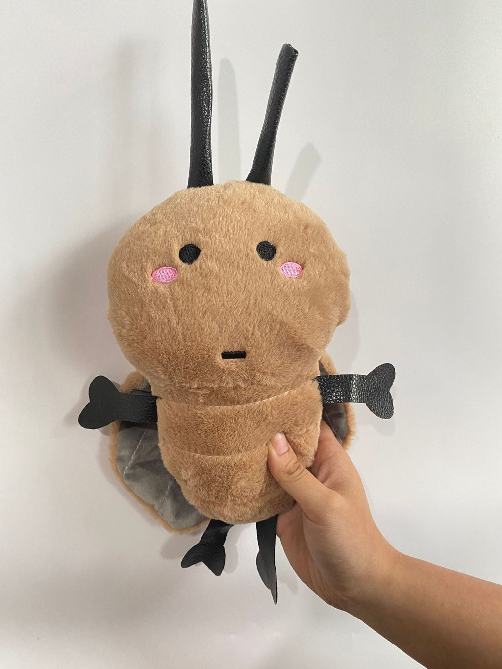 Roach Plush Toy cuddled in hands