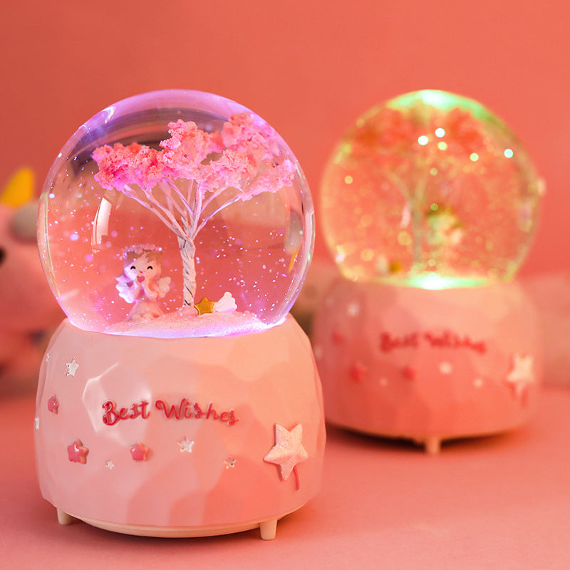 Illuminated cherry blossom angel inside snow globe