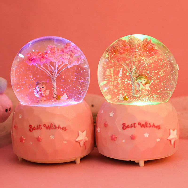 Back view of snow globe showcasing cherry blossom angel