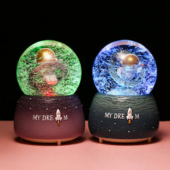 Close-up of astronaut in snow globe music box