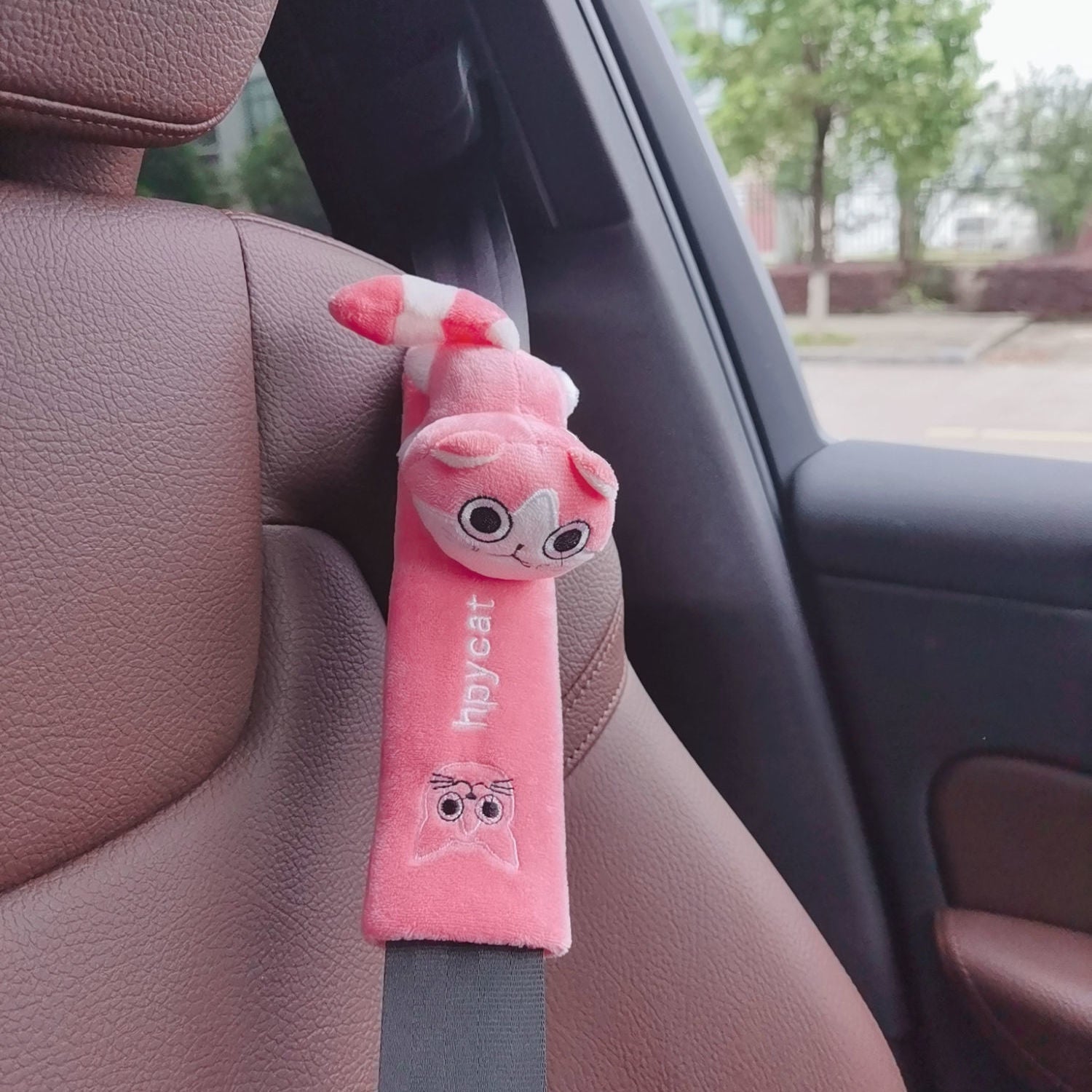 Fun grey cartoon seat belt pad in a car