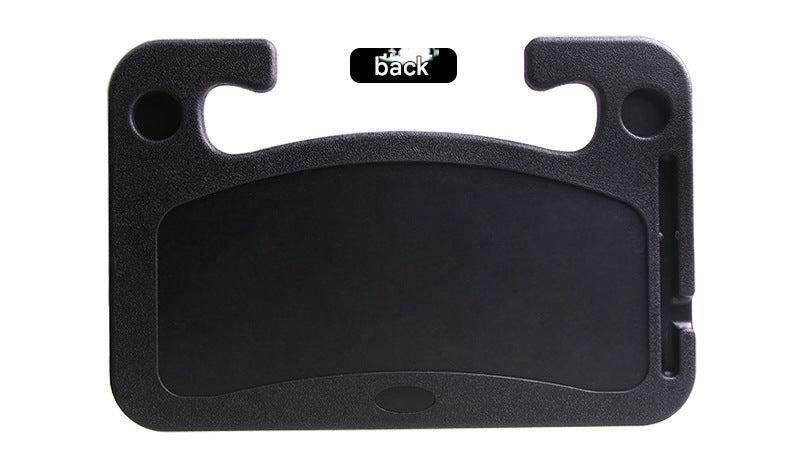 Grey car steering wheel desk supporting a laptop