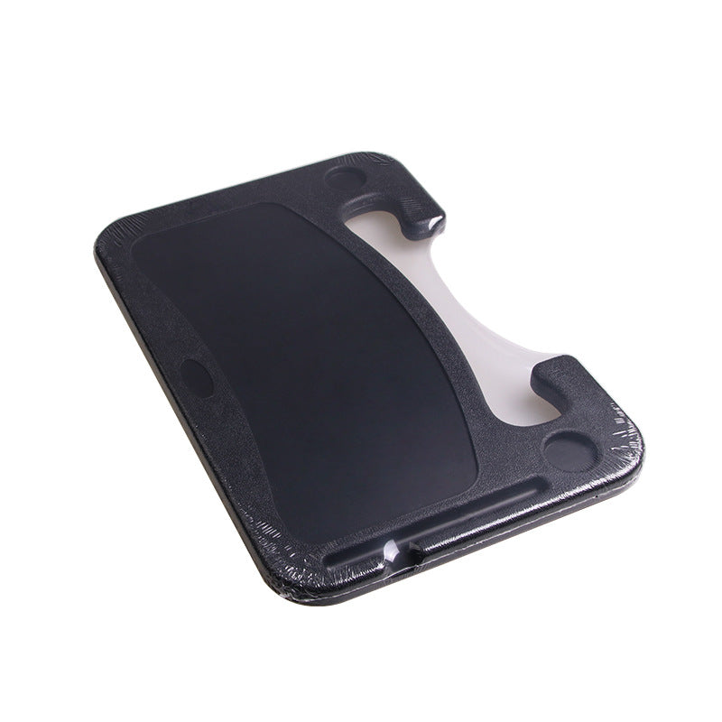 Grey car steering wheel desk supporting a laptop
