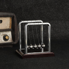Newton's Cradle on an office desk demonstrating physics