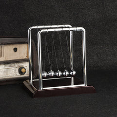 Close-up of black base Newton's Cradle in action