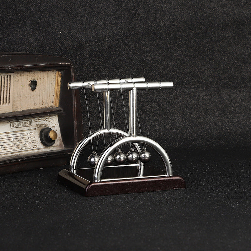 Newton's Cradle on an office desk demonstrating physics