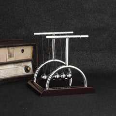 Close-up of black base Newton's Cradle in action