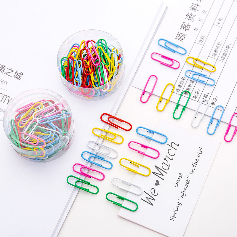 Box of multicoloured curved paper clips