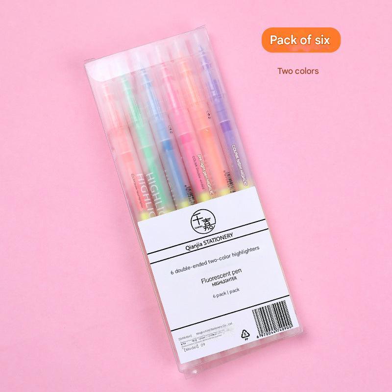 various highlighter pens arranged on a notebook