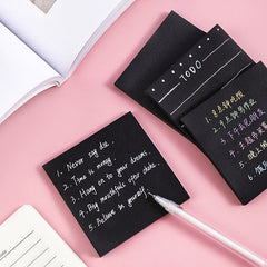 Close-up of black memo pad with writing