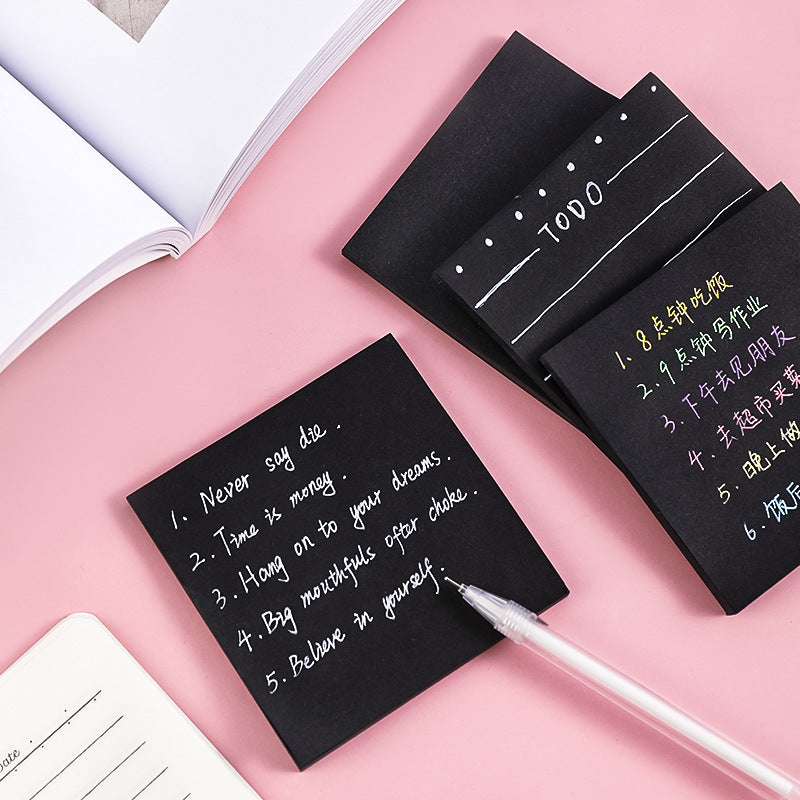 Close-up of black memo pad with writing