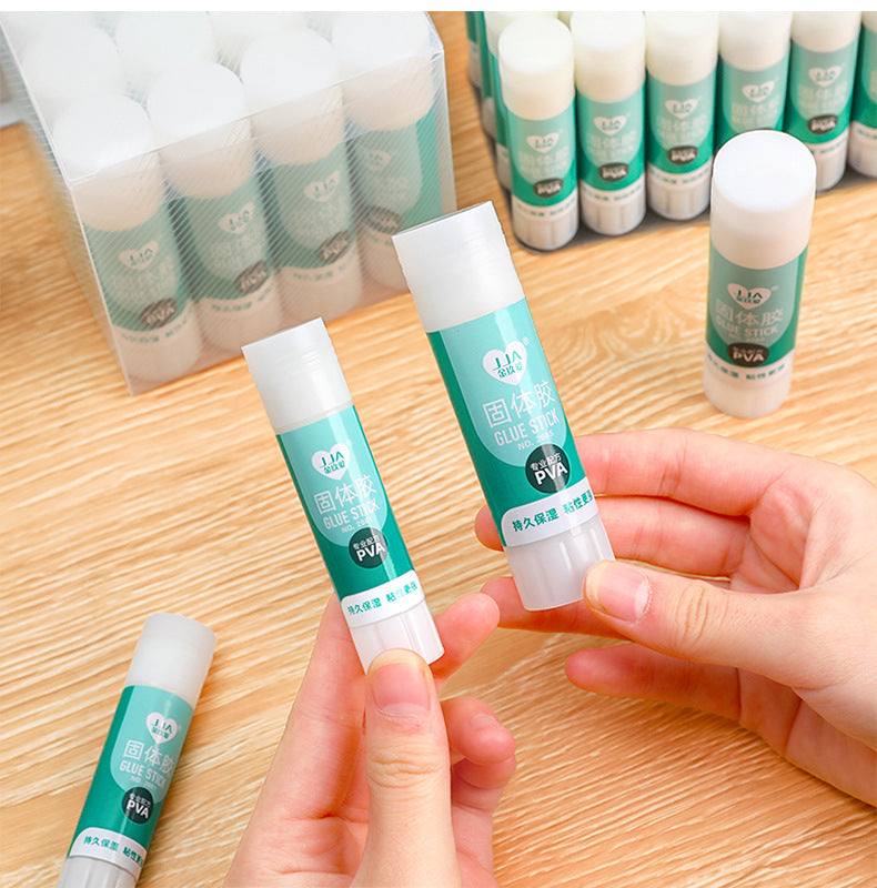 solid glue stick in-use sticking two papers