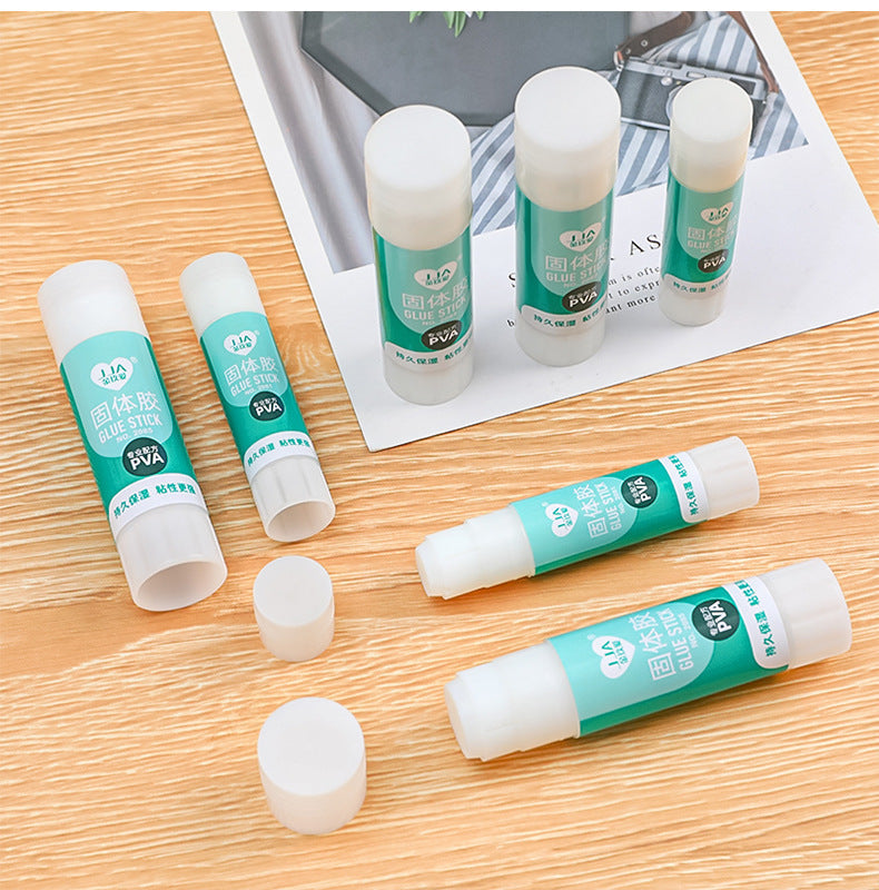 solid glue stick on desk with school supplies
