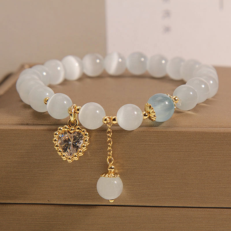 Close-up of cat eye stone bracelet showcasing heart pendant