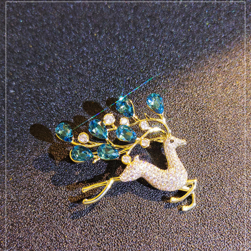 Elegant blue crystal deer brooch on display