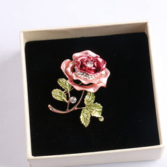 Floral brooch beside different colour variations
