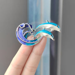 Close-up of Dolphin Brooch with oil drip finish