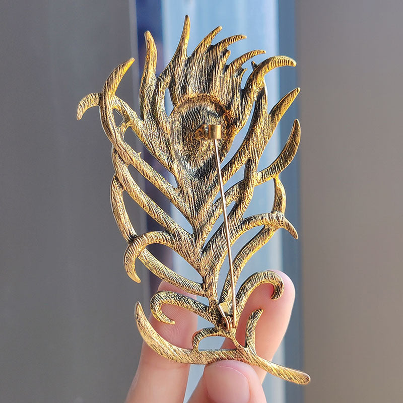 Close-up of colorful brooch with feather design image 3