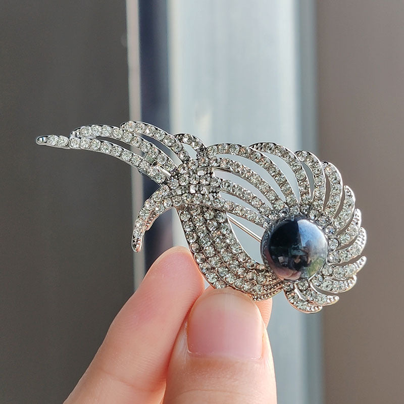 Close-up of feather brooch featuring pearl accents