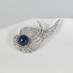 Elegant brooch with pearl on a detailed background
