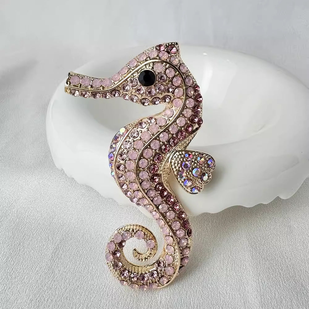 Elegant pink sea horse enamel pin displayed