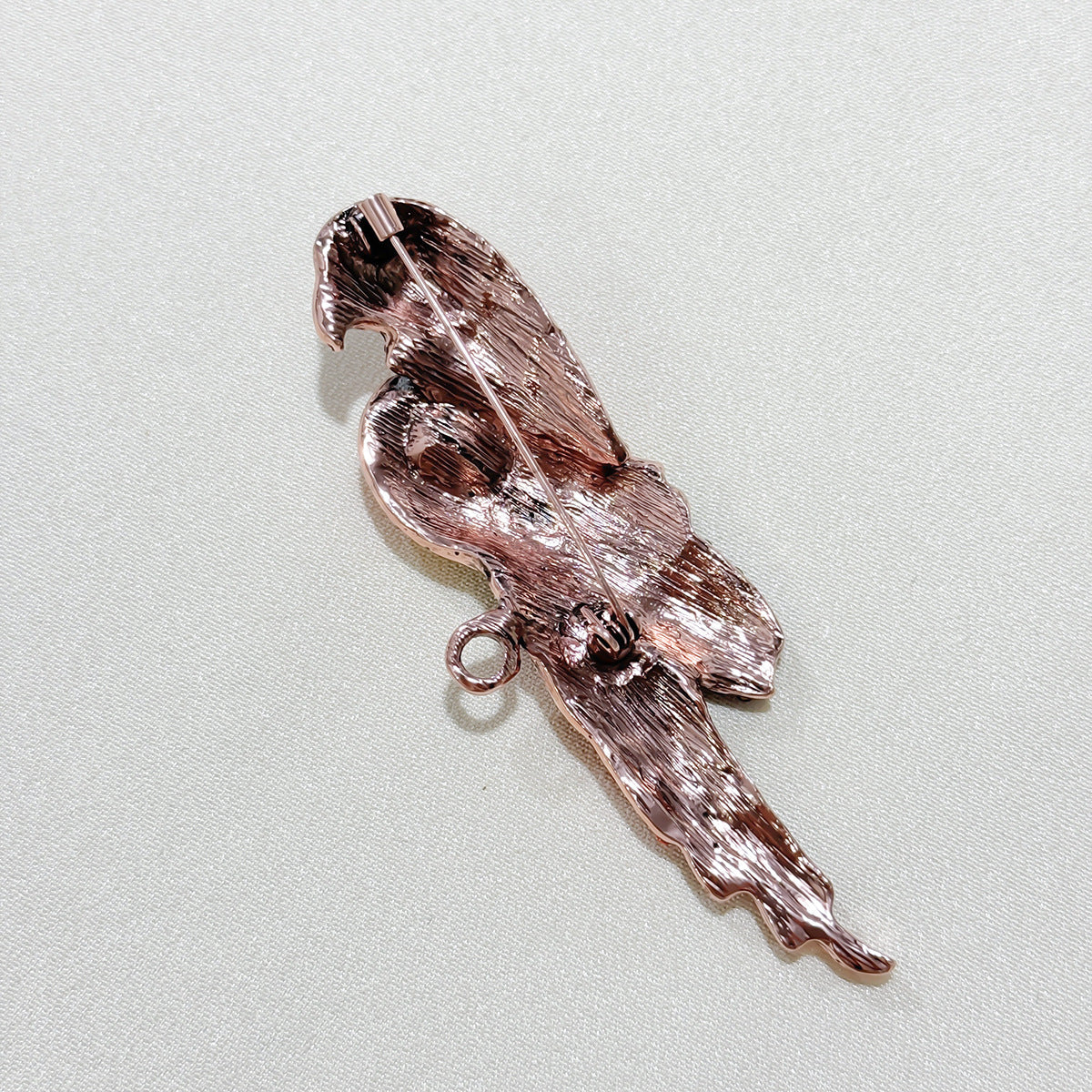 Close-up of the vibrant red parrot brooch