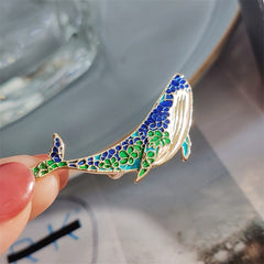 Whale and dolphin brooch laid flat on a surface