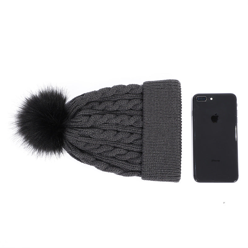 Dark grey knit beanie with pom pom displayed
