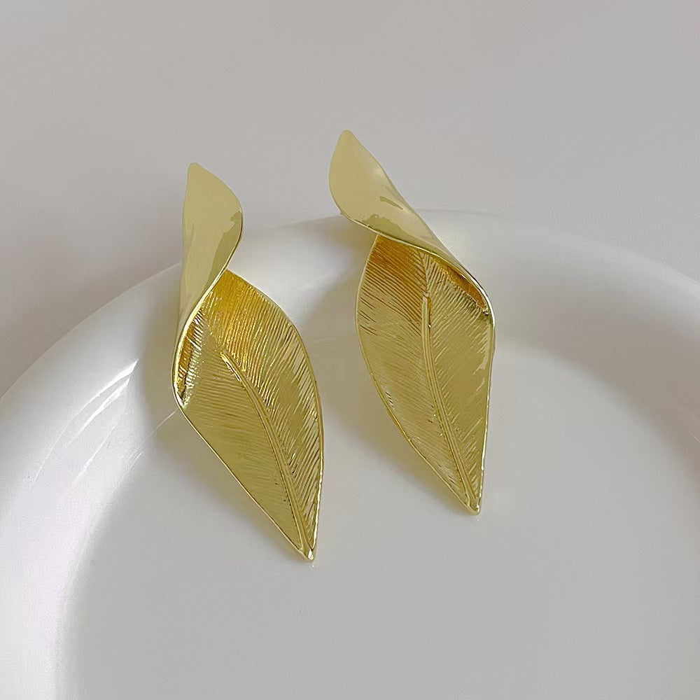 Silver leaf statement earrings worn by model