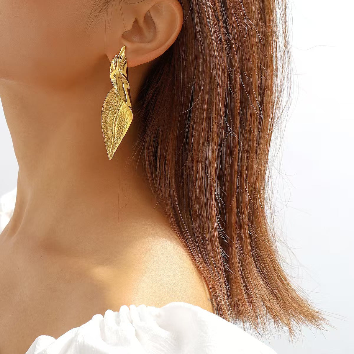 Silver leaf statement earrings worn by model