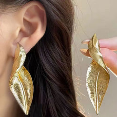 Close-up of gold and silver vintage leaf earrings