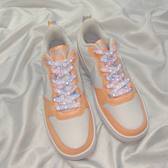 Red-pink reflective shoelaces on casual footwear