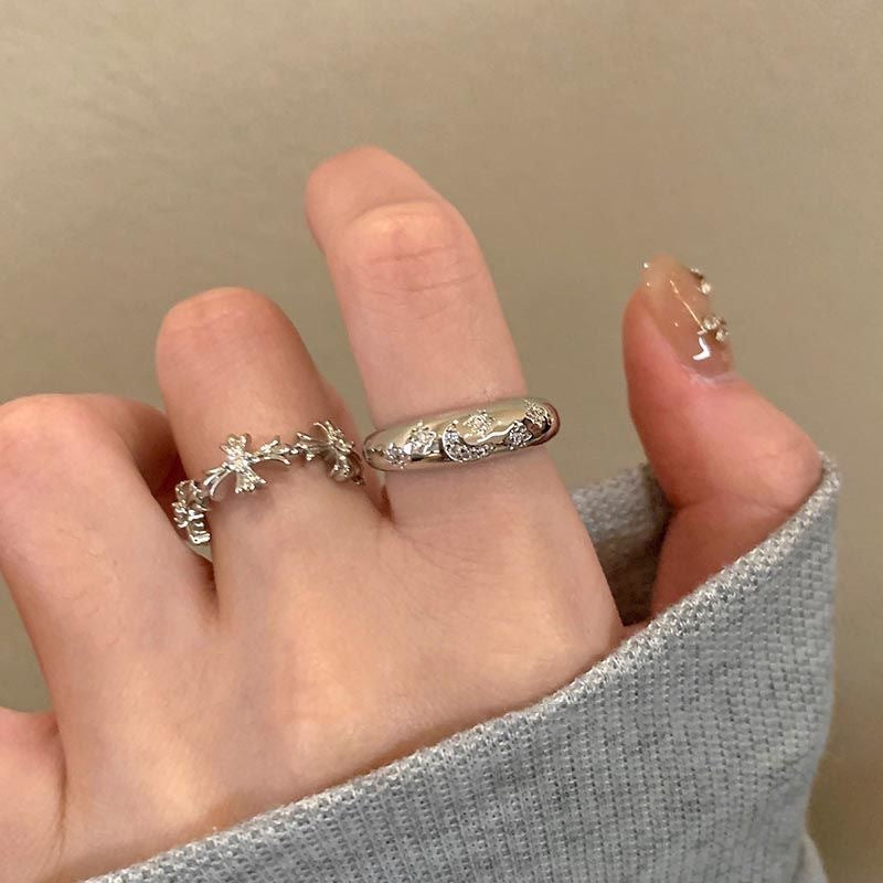 silver zircon cross ring on display with background