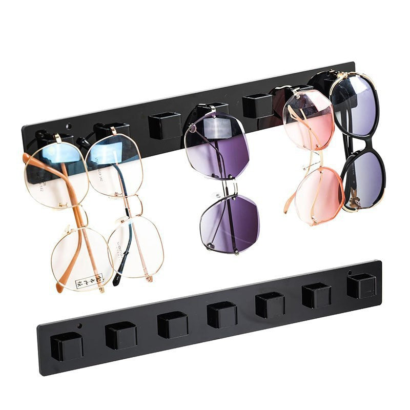 Black acrylic sunglasses rack showcasing various styles