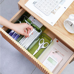Clear plastic storage box showing various office supplies