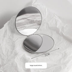 Stainless steel portable makeup mirror on table