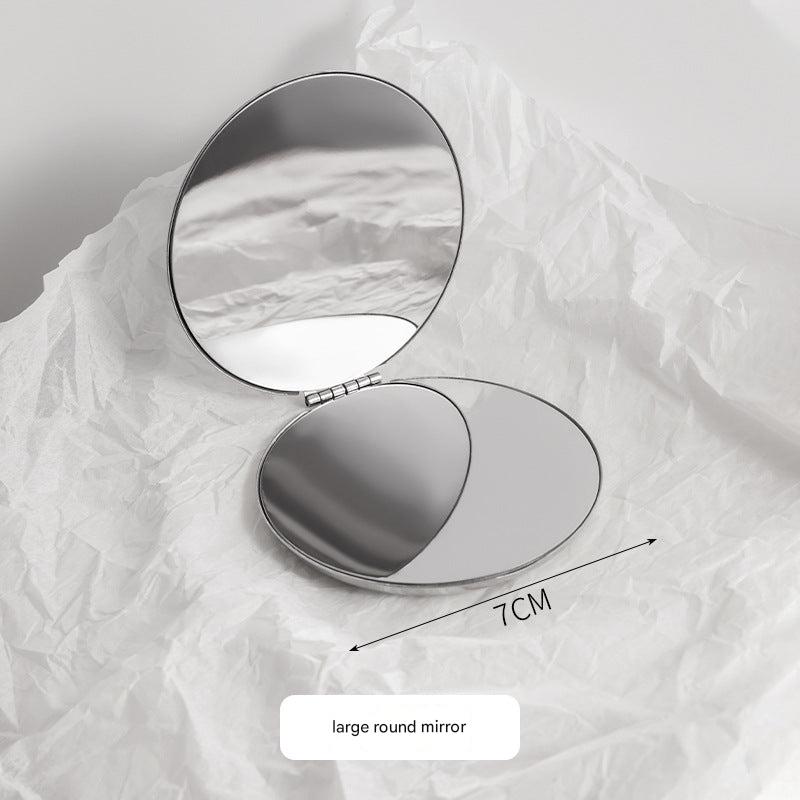 Stainless steel portable makeup mirror on table