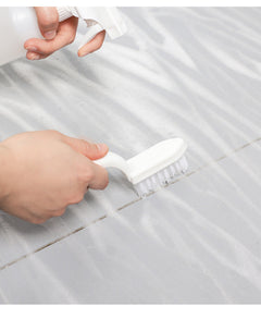 Bathroom tile cleaner brush in action