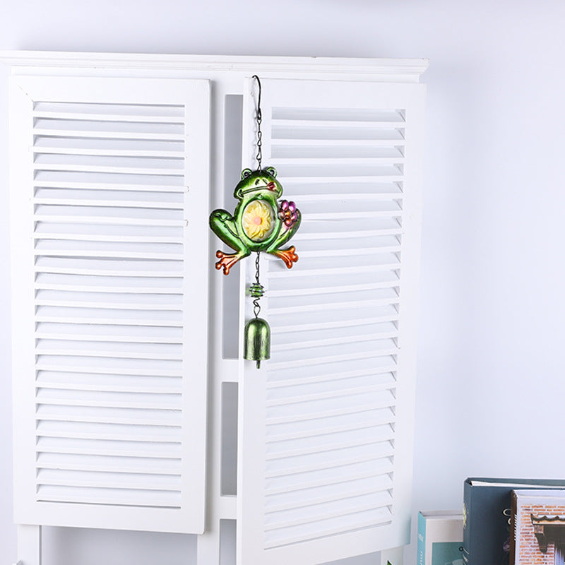 Close-up of colourful glass accents on frog wind chime