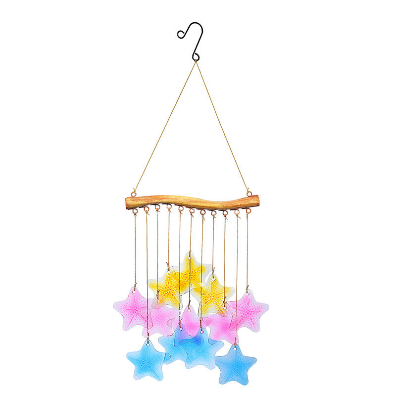 Colorful glass fish and leaf wind chime hanging in a garden