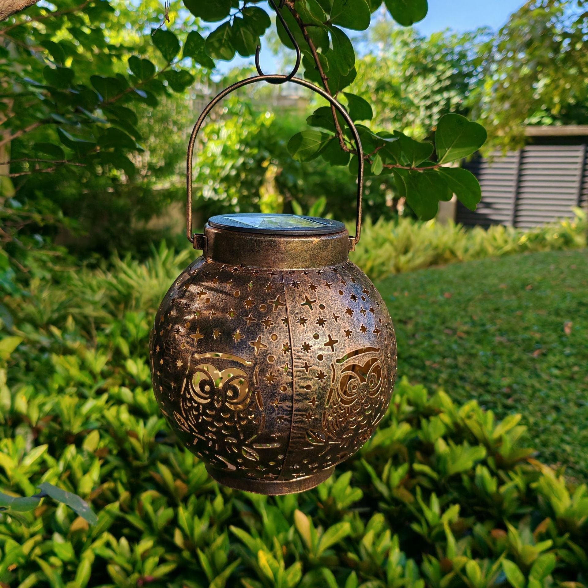 Metal solar light illuminating a garden
